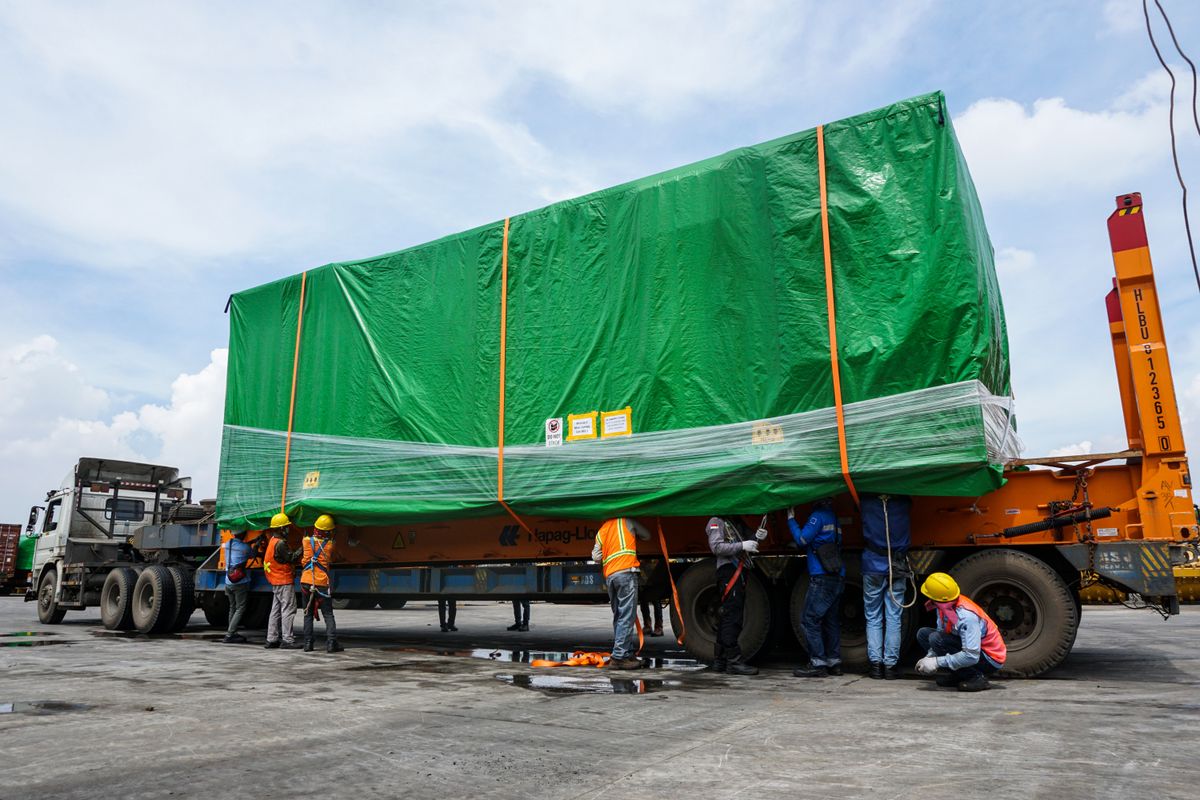 Workers and a freight container on a road trailer