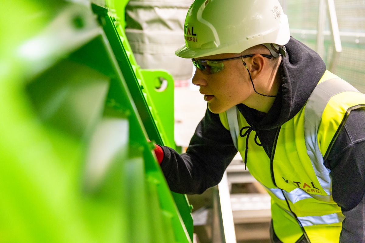 Engineer inspecting industrial equipment in safety gear